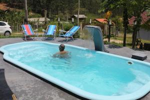 a person in a jacuzzi in a swimming pool at casa de campo Chalé bela vista in Tijucas