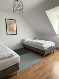 a bedroom with two beds and a rug at City Nest Ettlingen - nähe Wasenpark in Ettlingen