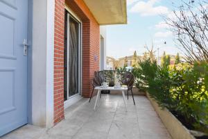 a chair sitting on a porch with a table at Joli T2 avec terrasse et Parking in Toulouse