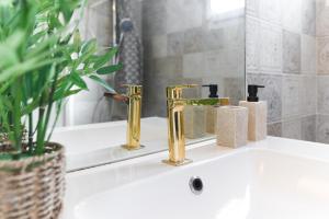 a bathroom sink with two gold faucets on it at Joli T2 avec terrasse et Parking in Toulouse