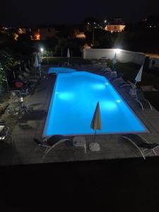 a large blue swimming pool with chairs and a umbrella at Al Mare da Francesca in Olbia