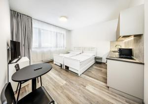 Una cocina y una sala de estar con una mesa. en Residence Riverside, en Pec pod Sněžkou