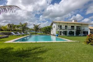 ein Swimmingpool vor einem Haus in der Unterkunft Tudo Bom Kitesurf Dream Villa in Taíba