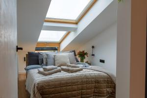 a bedroom with a large bed with a skylight at Apartamenty PREMIUM 56 obok Rynku Centrum, Parking - GARAŻ PODZIEMNY, wysoki standard, spokojna i cicha okolica, Parking - UNDERGROUND GARAGE, high standard, peaceful and quiet area in Kielce