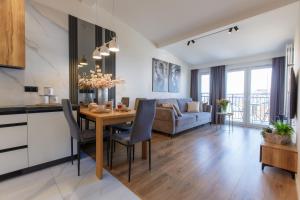 a kitchen and living room with a table and a couch at Apartamenty PREMIUM 56 obok Rynku Centrum, Parking - GARAŻ PODZIEMNY, wysoki standard, spokojna i cicha okolica, Parking - UNDERGROUND GARAGE, high standard, peaceful and quiet area in Kielce