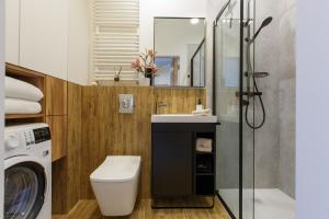 a bathroom with a sink and a washing machine at Apartamenty PREMIUM 56 obok Rynku Centrum, Parking - GARAŻ PODZIEMNY, wysoki standard, spokojna i cicha okolica, Parking - UNDERGROUND GARAGE, high standard, peaceful and quiet area in Kielce +18 photos