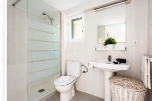 a bathroom with a toilet and a sink and a shower at Menorca Apartamento ALOHA by Mauter Villas in Cala en Blanes +16 photos