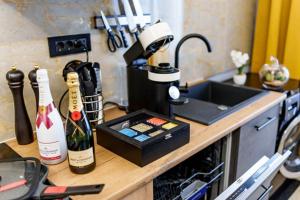 a kitchen counter with two bottles of wine and a sink at Modernes LuxusApartment in Essen in Essen