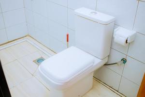 a bathroom with a white toilet in a room at BC Empire Luxury Guest House in Kigali
