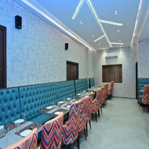 a row of tables and chairs in a dining room at Raj Regency in Vilad