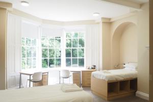 a bedroom with two beds and a desk and a window at St Chad's College in Durham