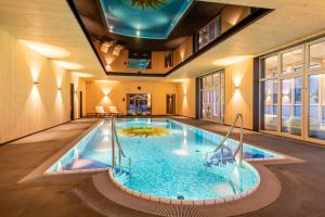 a swimming pool in a hotel with a ceiling at FAIR RESORT All Inclusive Wellness & Spa Hotel Jena in Jena