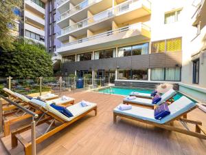 a building with a swimming pool and two beds at Croisette Beach Hotel Cannes - MGallery Collection in Cannes