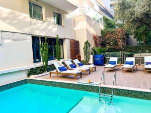 a patio with chairs and a swimming pool at Croisette Beach Hotel Cannes - MGallery Collection in Cannes