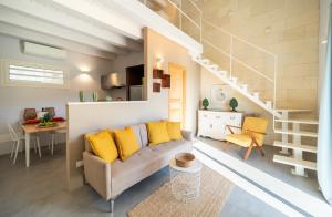 een woonkamer met een bank en een trap bij Azalo Country House in Noto