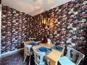 a dining room with a table and a floral wall at Pension Winnemuller in Cochem
