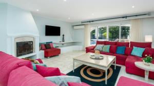 a living room with a red couch and a fireplace at Villa Florida in Almancil