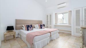 a bedroom with a large bed and a window at Villa Florida in Almancil +20 photos