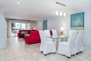 a living room with a table and a red couch at Villa Florida in Almancil