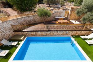 a swimming pool in a yard with a stone wall at Excesio in Gerani