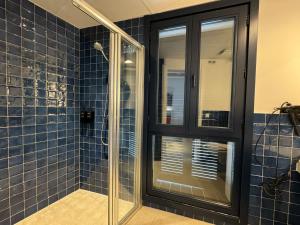 a bathroom with a glass shower with blue tiles at Hotel Boutique Es Blau in Cadaqués +59 photos