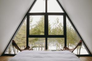 a large window in a room with a bed and chairs at Woodlander Mountain House Blidinje in Blidinje +126 photos