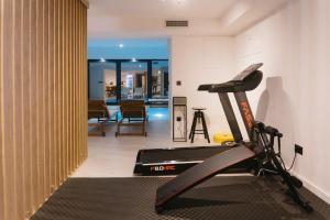 a room with a treadmill and a living room at Woodlander Mountain House Blidinje in Blidinje