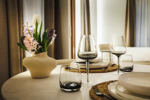 a table with two wine glasses and a vase with flowers at Corral del Carbón GG Luxury Hotel Boutique in Granada +106 photos