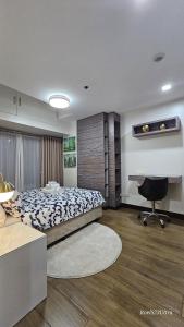 a bedroom with a bed and a desk in it at Your HOME away from home in Manila