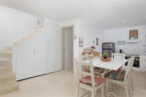 a kitchen with a table and chairs and a staircase at Kastellas' Dream in Kithnos