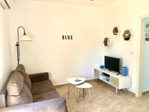 a living room with a couch and a tv at B&P Miami playa Blue in Miami Platja