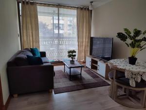a living room with a couch and a table and a television at FRONT Rioja in Viña del Mar