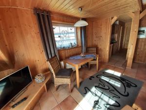 Una sala de estar con una mesa y un televisor. en Fewo Holzwurm, en Braunlage