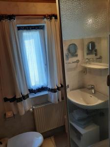 Un baño con lavabo, inodoro y ventana. en Fewo Holzwurm, en Braunlage 36 fotos más