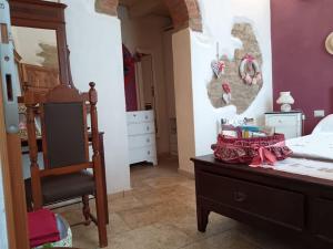 a bedroom with a bed and a chair and a dresser at Casa Vacanze Porta a Mare in Scarlino