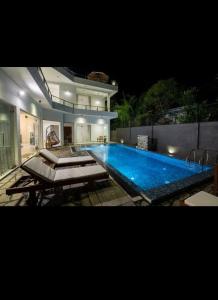 a large swimming pool in front of a house at night at Villa Mossa Ambalangoda Boutique villa villa in Ambalangoda +114 photos