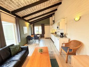a living room with a couch and a table at Bungalowpark Simpelveld - Schakel 15 in Simpelveld