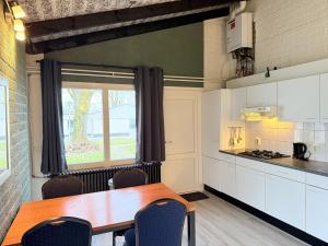 a kitchen with a table and chairs and a window at Bungalowpark Simpelveld - Schakel 15 in Simpelveld +3 photos