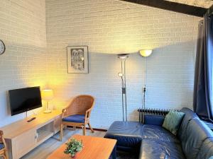 a living room with a couch and a tv at Bungalowpark Simpelveld - Schakel 15 in Simpelveld