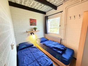 two beds in a room with a window at Bungalowpark Simpelveld - Schakel 15 in Simpelveld