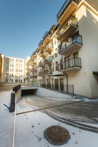a large apartment building with balconies and a manhole at Apartamenty PREMIUM 56 obok Rynku Centrum, Parking - GARAŻ PODZIEMNY, wysoki standard, spokojna i cicha okolica, Parking - UNDERGROUND GARAGE, high standard, peaceful and quiet area in Kielce