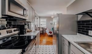 a kitchen with stainless steel appliances and a dining room at Visit for Formula 1, Stay at Magic Tree House at UT, Dtwn in Austin