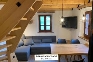 a living room with a blue couch and a table at Apartma Povlč in Poljane nad Škofjo Loko
