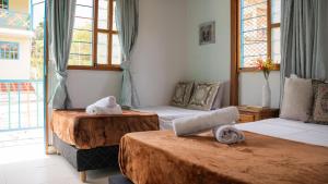 een kamer met twee bedden met handdoeken erop bij Las Casas de Tomate in Guatapé