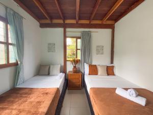 een slaapkamer met twee bedden en een raam bij Las Casas de Tomate in Guatapé