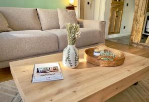 una mesa de centro con un jarrón y un libro sobre él en Le Pianiste, en hypercentre avec balcon, en Limoges