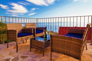 a group of chairs and tables on a balcony overlooking the ocean at Wunderschöne Steinvilla Mit Tollem Ausblick in Podgora