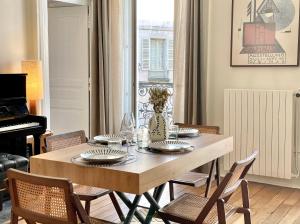 comedor con mesa con sillas y piano en Le Pianiste, en hypercentre avec balcon, en Limoges