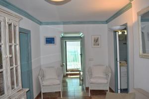una stanza con due sedie e un corridoio con una porta di Casa Berrincha a Cómpeta