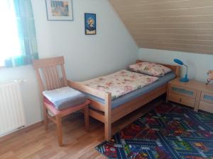 a bed and a chair in a room at Wohnung In Oberwaldbach Mit Garten Und Grill in Burtenbach +20 photos